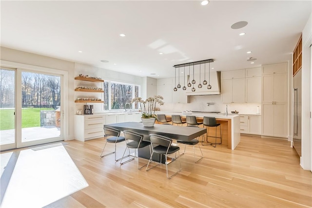 kitchen with a kitchen breakfast bar, pendant lighting, a center island, and a healthy amount of sunlight