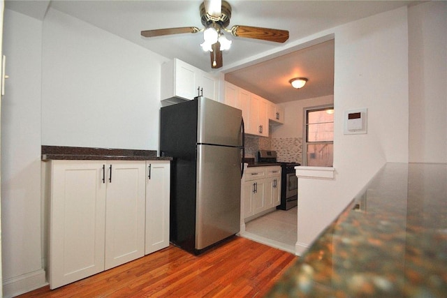 kitchen featuring white cabinetry, backsplash, appliances with stainless steel finishes, and light hardwood / wood-style flooring