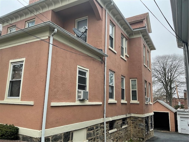 view of side of home featuring cooling unit and a garage