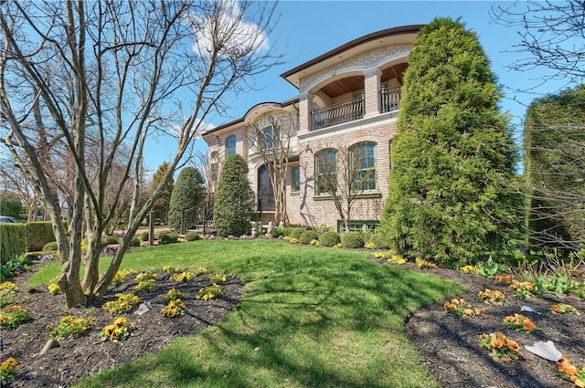 view of front of house with a front yard and a balcony