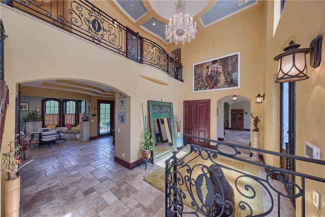 entryway featuring a towering ceiling and an inviting chandelier