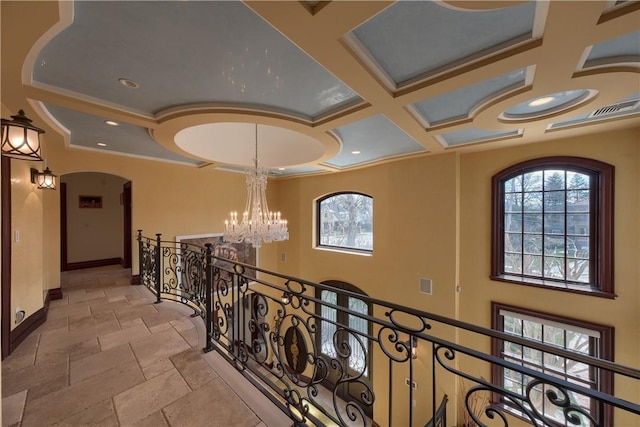 corridor featuring a chandelier, ornamental molding, and coffered ceiling