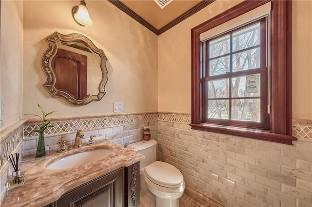 bathroom featuring vanity, toilet, tile walls, and crown molding