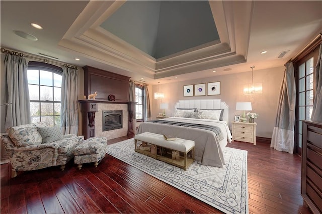 bedroom with a tray ceiling and dark hardwood / wood-style flooring