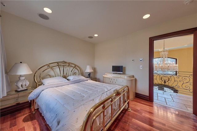 bedroom with hardwood / wood-style floors and a notable chandelier