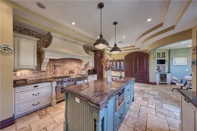 kitchen with a center island, hanging light fixtures, wine cooler, double oven range, and custom exhaust hood