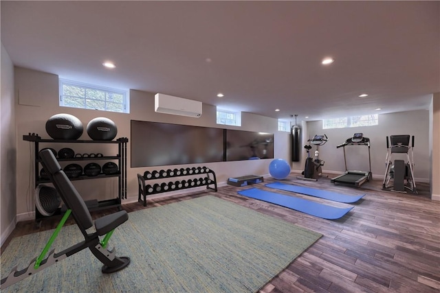 exercise area with a wall mounted AC and wood-type flooring