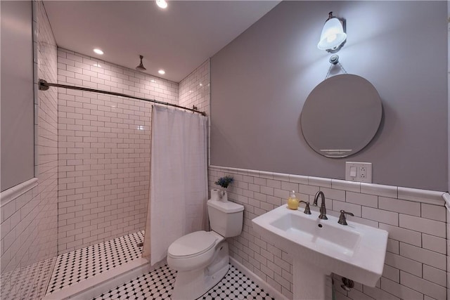 bathroom featuring sink, walk in shower, tile patterned flooring, toilet, and tile walls