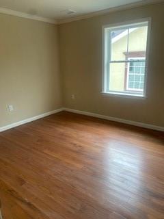 spare room with ornamental molding and hardwood / wood-style flooring