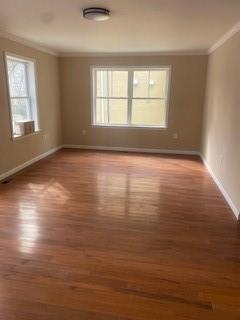 spare room featuring hardwood / wood-style flooring and ornamental molding