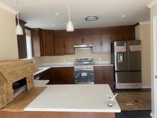 kitchen featuring pendant lighting, stove, stainless steel fridge with ice dispenser, and ornamental molding