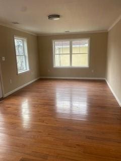 spare room with hardwood / wood-style flooring and crown molding