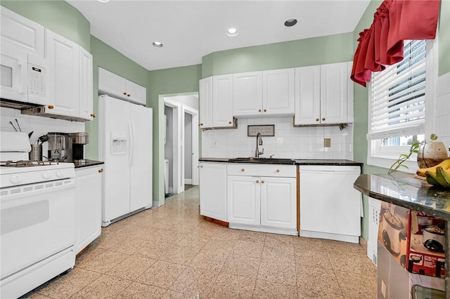 kitchen with white cabinets, backsplash, white appliances, and sink