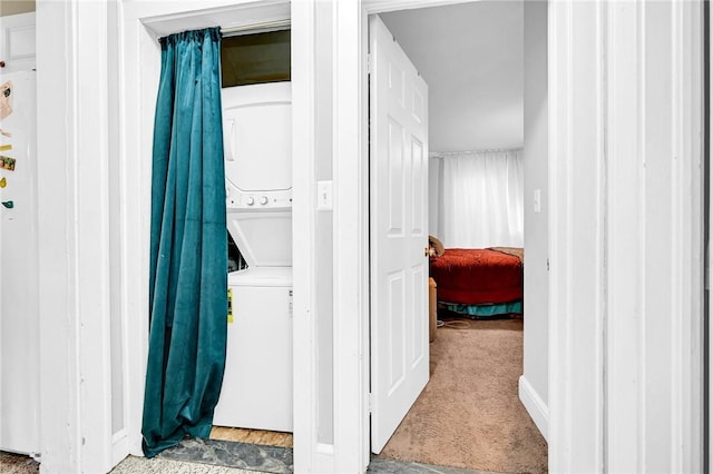 laundry area with carpet flooring and stacked washing maching and dryer