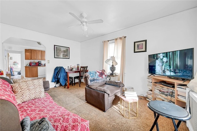 carpeted living room with ceiling fan