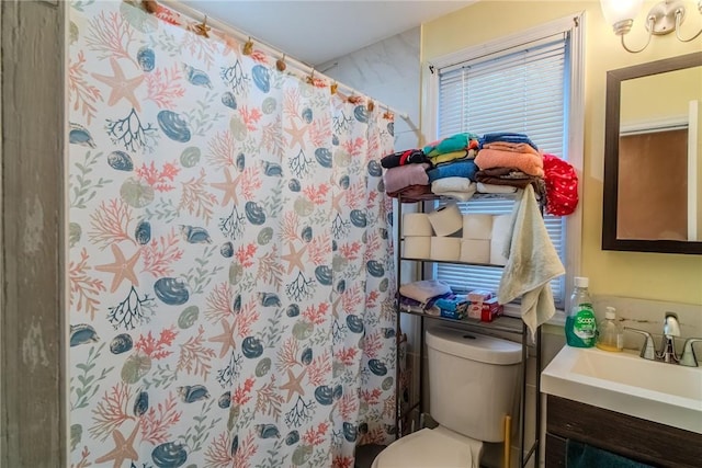 bathroom featuring curtained shower, vanity, and toilet