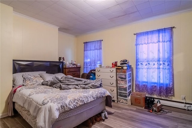 bedroom with hardwood / wood-style flooring and ornamental molding