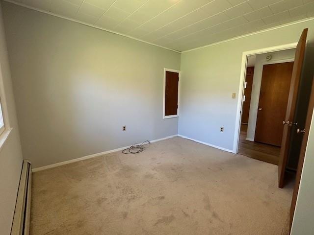 carpeted empty room with a baseboard heating unit