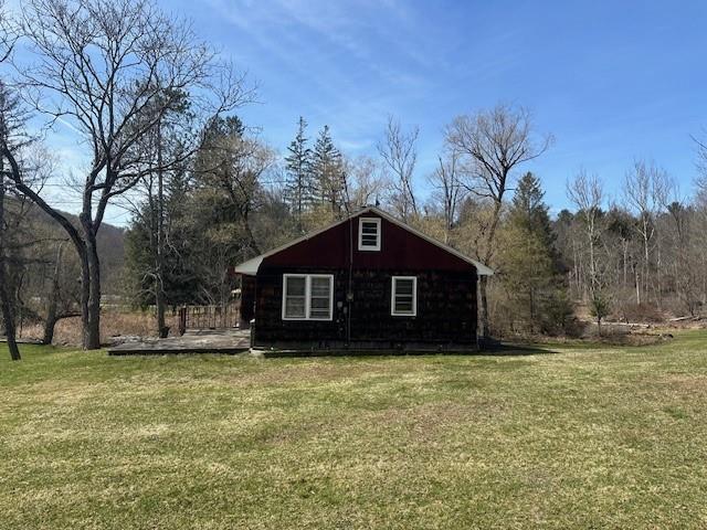 view of side of home with a yard