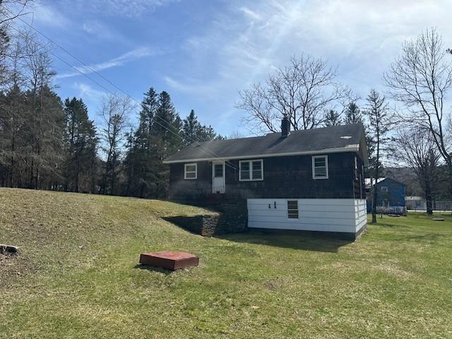 back of house with a lawn