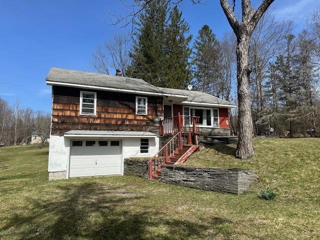 view of front of property featuring a front yard and a garage