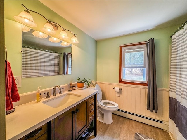 bathroom with vanity, toilet, wood-type flooring, and baseboard heating