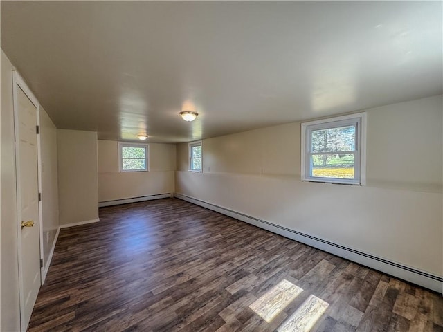 basement with dark hardwood / wood-style floors and a baseboard heating unit