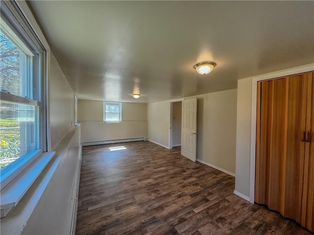 empty room with a baseboard heating unit and dark wood-type flooring