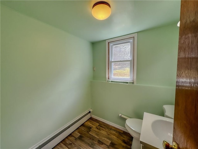 bathroom with toilet, vanity, a baseboard radiator, and hardwood / wood-style flooring