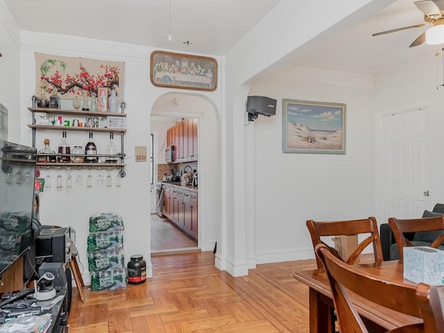 dining space with ceiling fan and light parquet floors