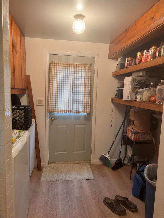 doorway to outside featuring washing machine and dryer and light wood-type flooring