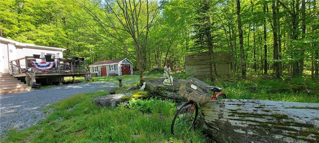 view of yard with a wooden deck and a storage unit