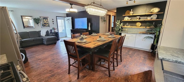 dining space with dark hardwood / wood-style flooring and a notable chandelier