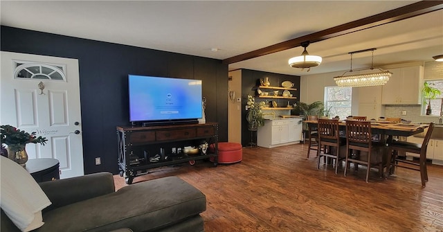 living room featuring beam ceiling and dark wood-type flooring