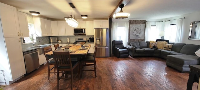 kitchen with white cabinets, pendant lighting, stainless steel appliances, and plenty of natural light