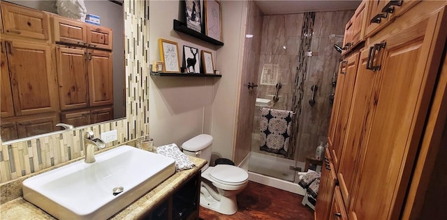 bathroom featuring a shower with door, vanity, and toilet