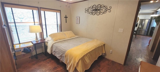 bedroom with stainless steel fridge, ornamental molding, and dark wood-type flooring