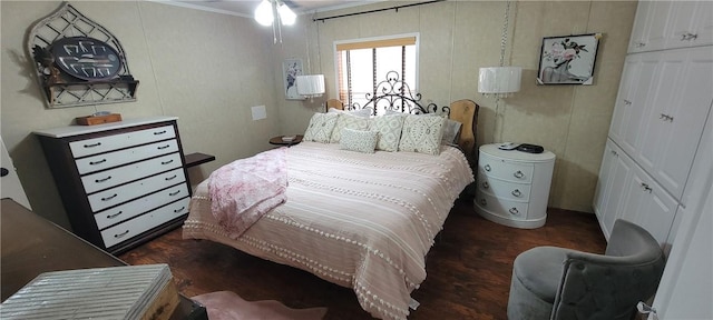 bedroom featuring ornamental molding and dark wood finished floors