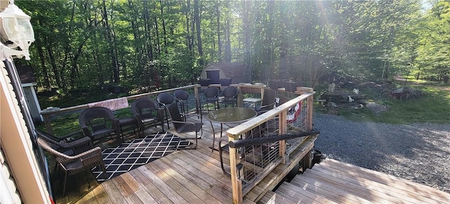 27 Birch Ln, Livingston Manor, NY 12768 - wooden terrace with a storage unit, outdoor dining area, and a view of trees