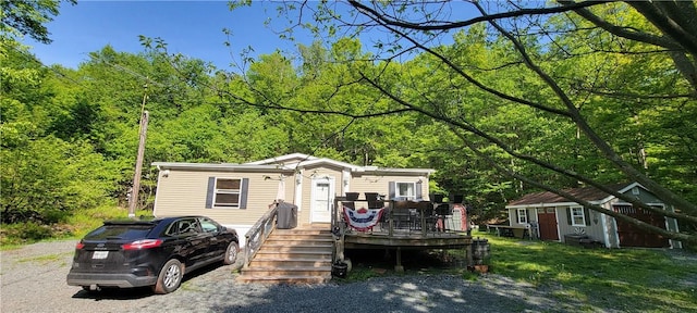 27 Birch Ln, Livingston Manor, NY 12768 - manufactured / mobile home with a deck, an outbuilding, and a wooded view