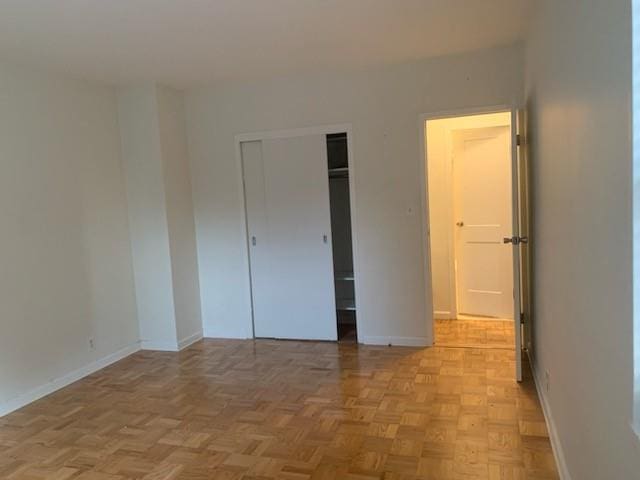 unfurnished bedroom with a closet and light parquet floors