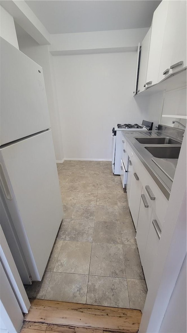 kitchen featuring white cabinets, white appliances, and sink