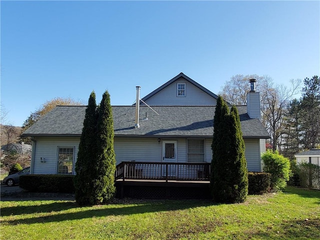 back of house featuring a deck and a lawn