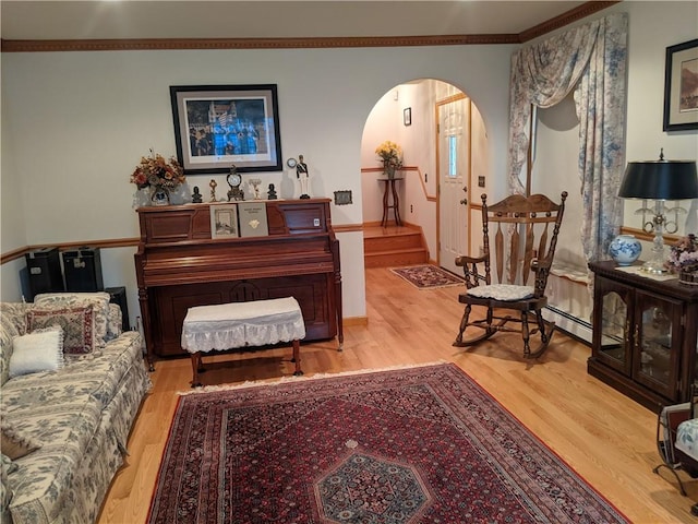 sitting room with wood-type flooring and ornamental molding