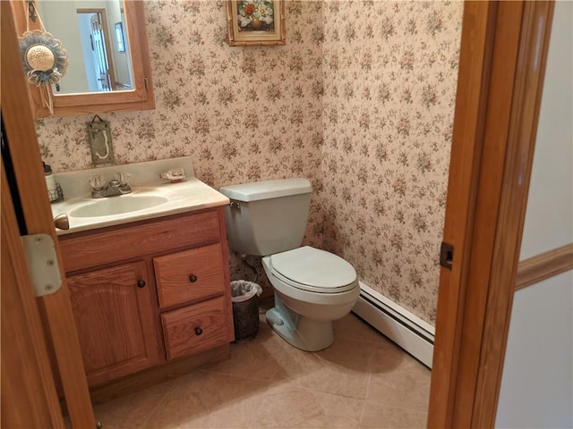 bathroom with tile patterned floors, toilet, vanity, and a baseboard heating unit