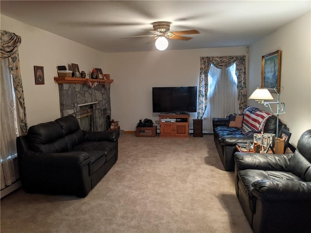 living room with carpet, ceiling fan, and a stone fireplace