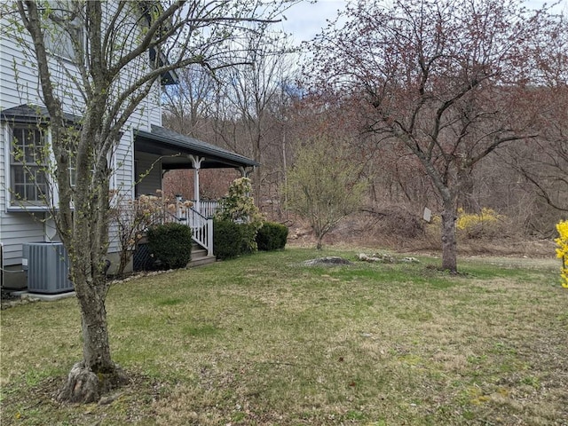 view of yard featuring a porch and central air condition unit