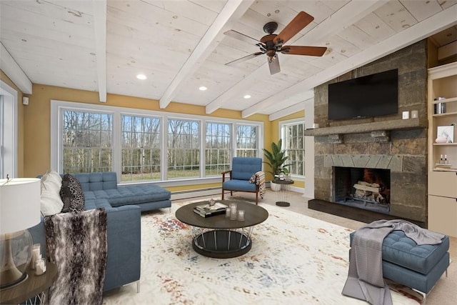 living room featuring a large fireplace, lofted ceiling with beams, ceiling fan, and a healthy amount of sunlight