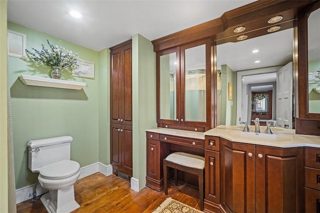 bathroom featuring toilet, vanity, and hardwood / wood-style flooring