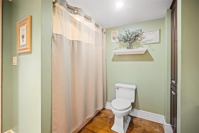 bathroom featuring a shower with curtain, wood-type flooring, and toilet